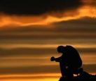 kneeling man at sunset
