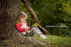 reading little girl by tree